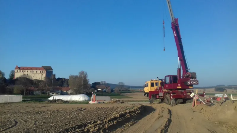 Autojeřáb AD 20T se vztyčeným ramenem na staveništi v otevřené krajině